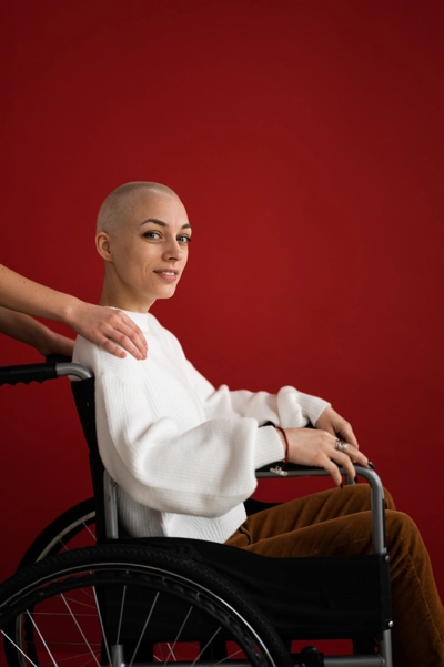A woman in a wheelchair in front of a red wall